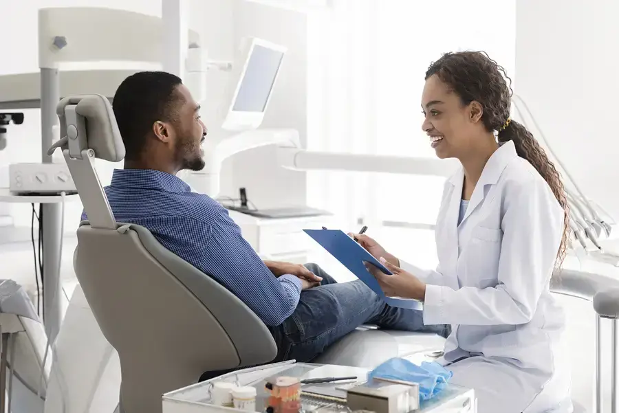 Dentist discussing emergency dental treatment with patient in modern dental office.