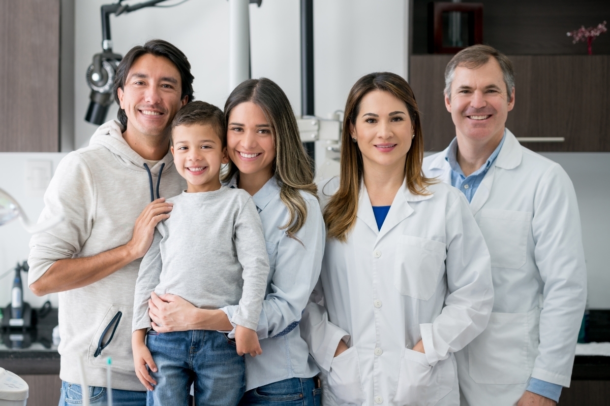 Friendly dental team with family at Lake Ridge family dental practice in Virginia.