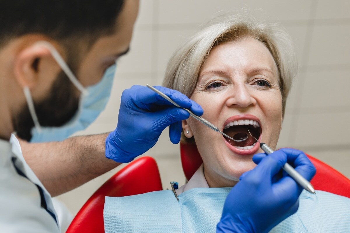 Dentist examining patient's teeth during dental checkup in Lake Ridge, VA office.
