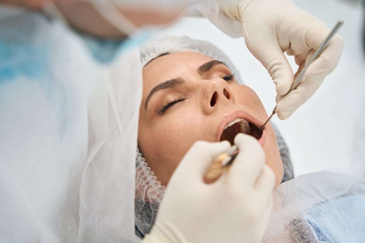 Dentist examining patient's teeth during dental checkup at Woodbridge, Virginia practice.